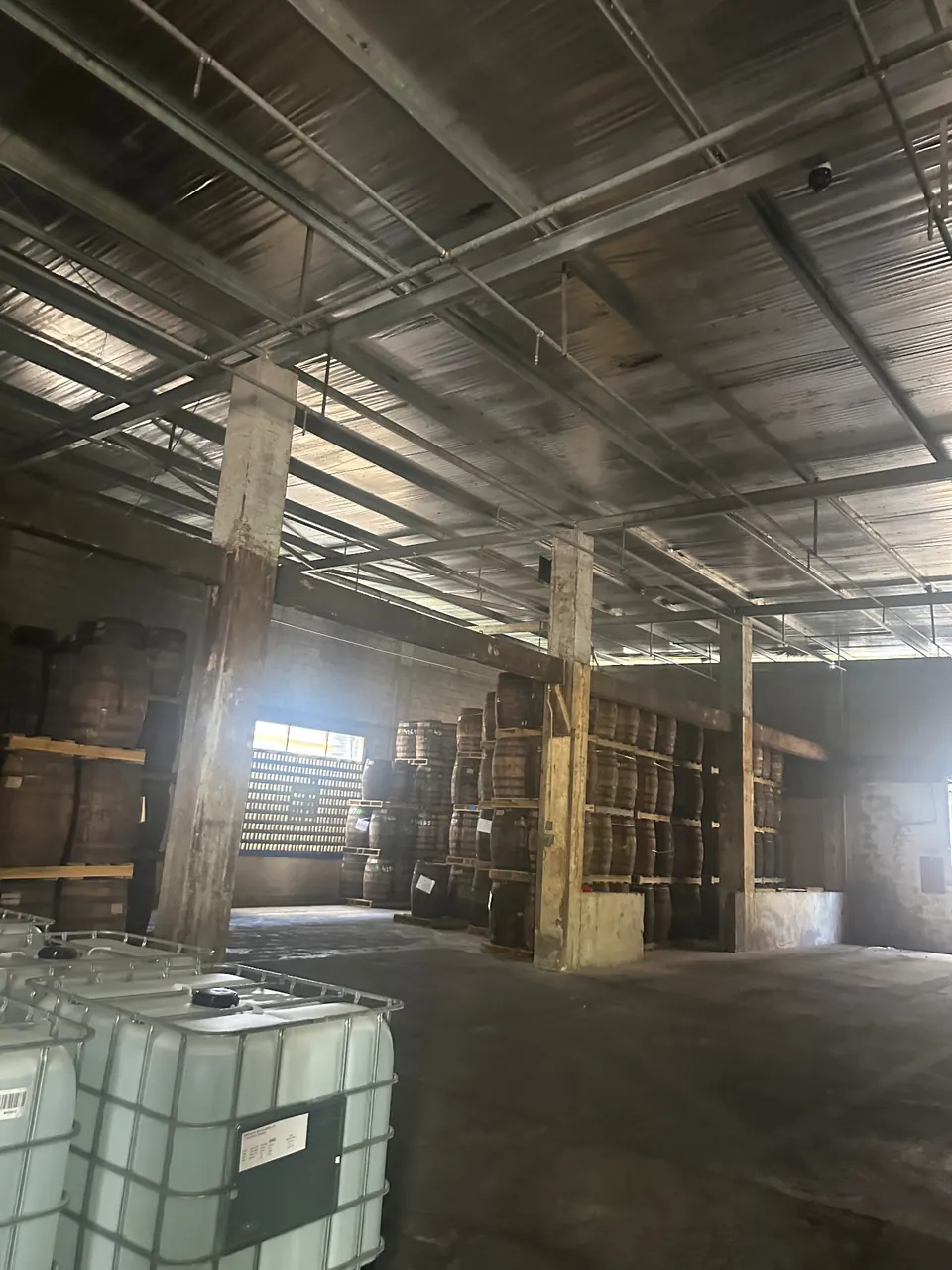 Wide barrel-storage view inside an industrial distillery